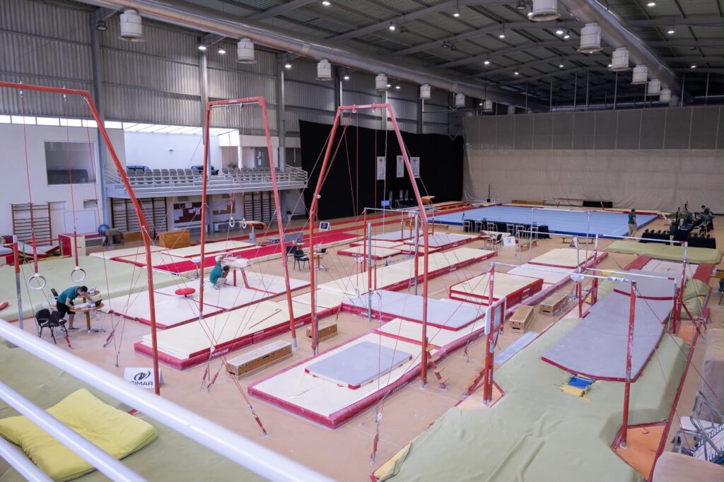 Interior de pavilhão de ginástica com aparelhos de competição